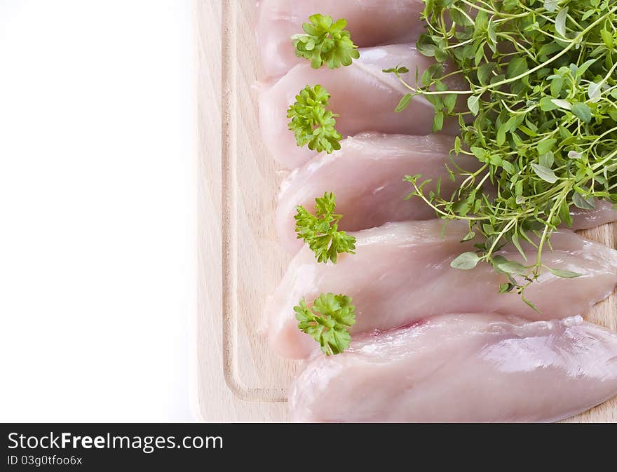 Raw chicken breasts on chopping board