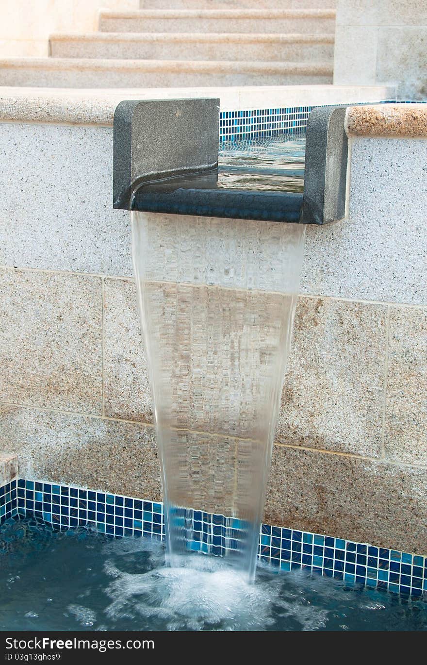 A portrait of water fountain with steps on the background