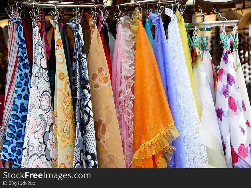 Various colorful scarfs on clothes-pegs sale at street outdoors