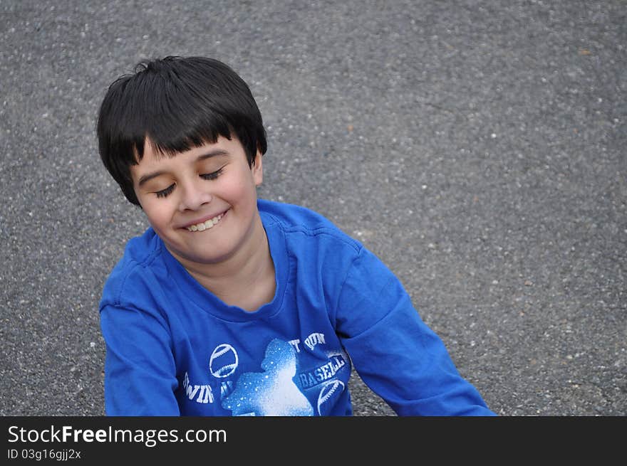 An adorable little boy has his eyes closed and he smiles happily, dreaming with his wonderful childhood. An adorable little boy has his eyes closed and he smiles happily, dreaming with his wonderful childhood.