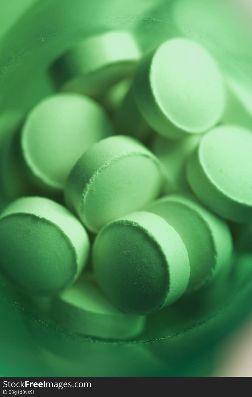 Macro view of pills shot in a green medicine bottle