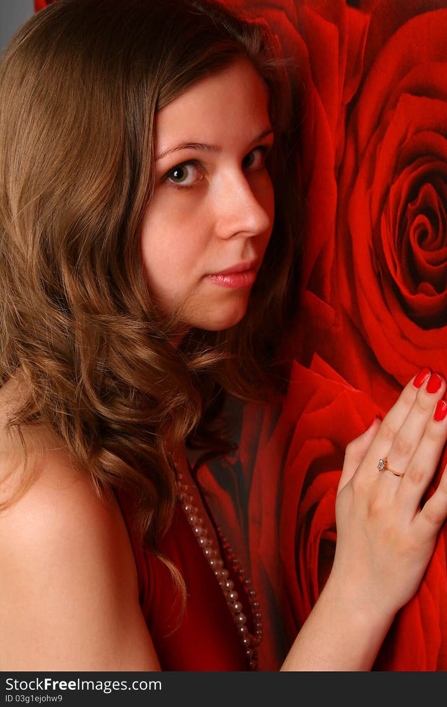 Cute girl posing at red wall and touch it with her hand. Cute girl posing at red wall and touch it with her hand.