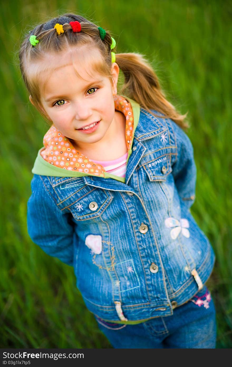 Cute little girl  on the meadow in spring day