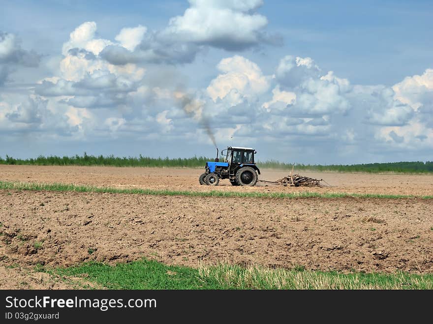 Tractor in the field. Planting work. Plow. Plowing the land.