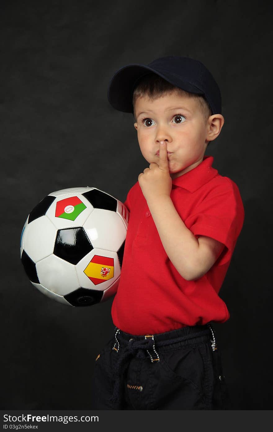 Portrait of the boy with a football on black