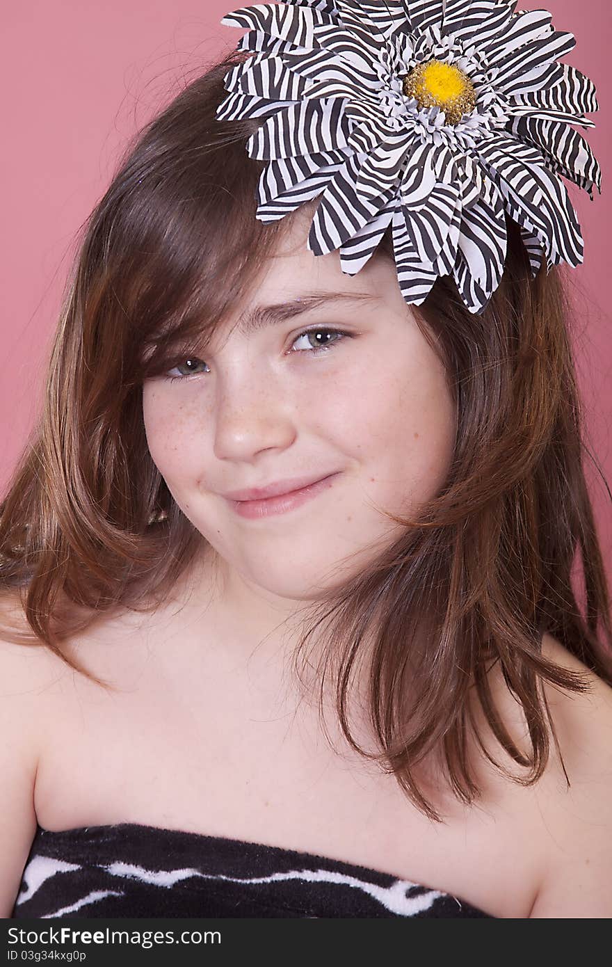 Preteen girl wearing a beautiful zebra striped flower in her hair. Preteen girl wearing a beautiful zebra striped flower in her hair.