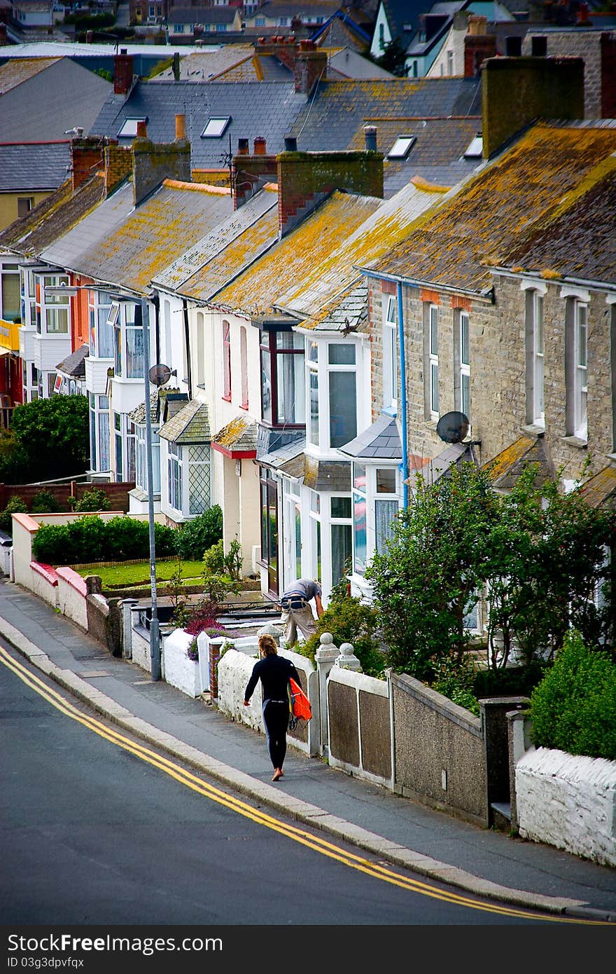 A row of houses and a surfer walking