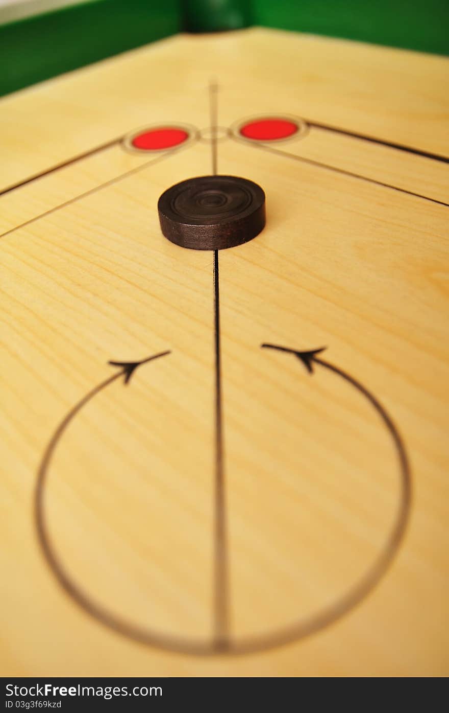 Photo of carrom board and coin.