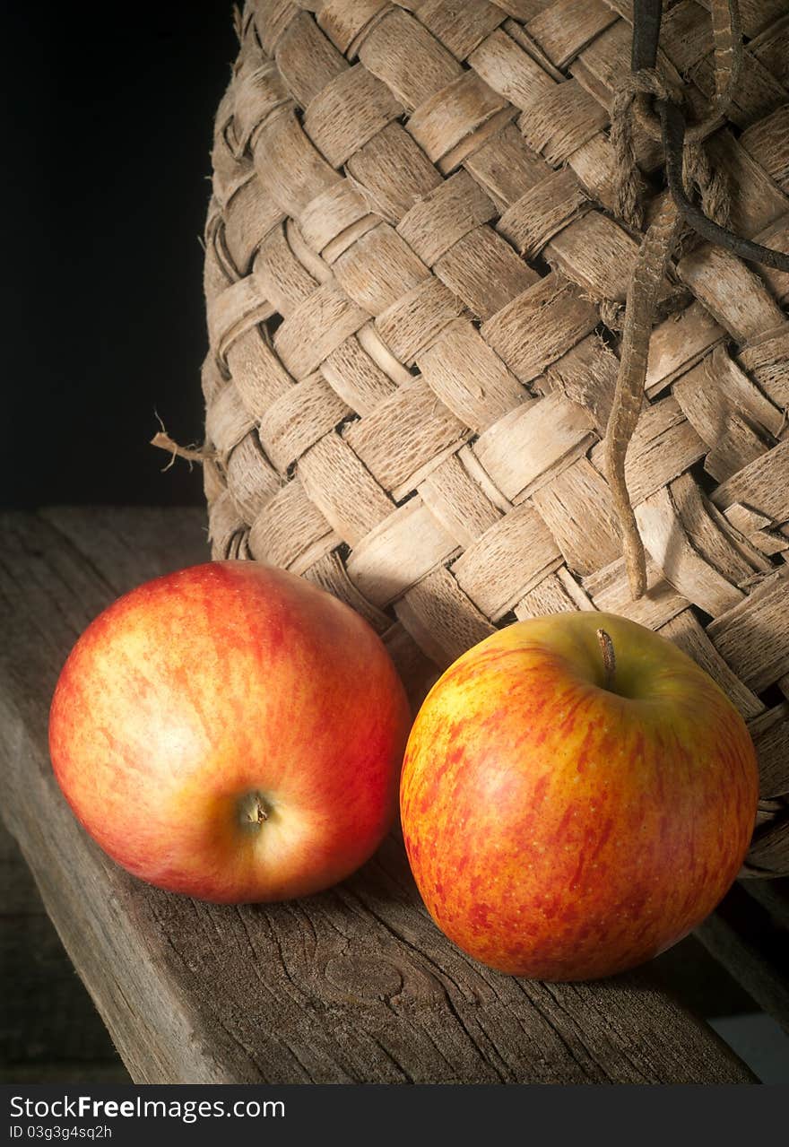 Still-life from apples and an old basket