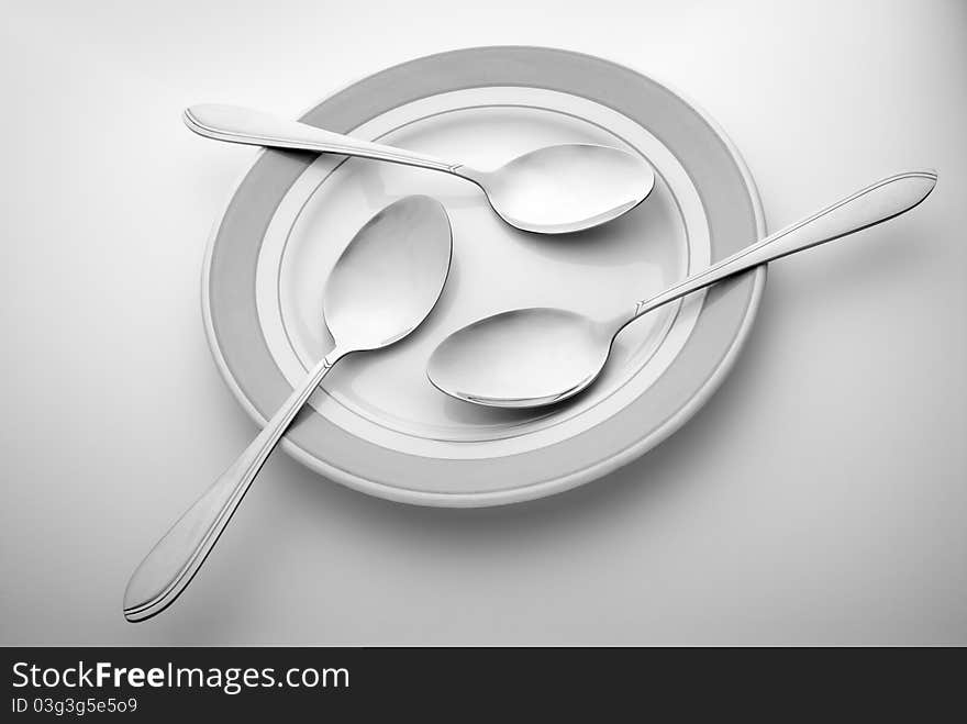 Three spoons lie on a plate. Three spoons lie on a plate