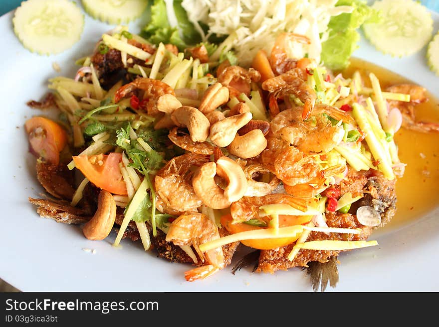 Thai food, deep fried fish with green mango salad