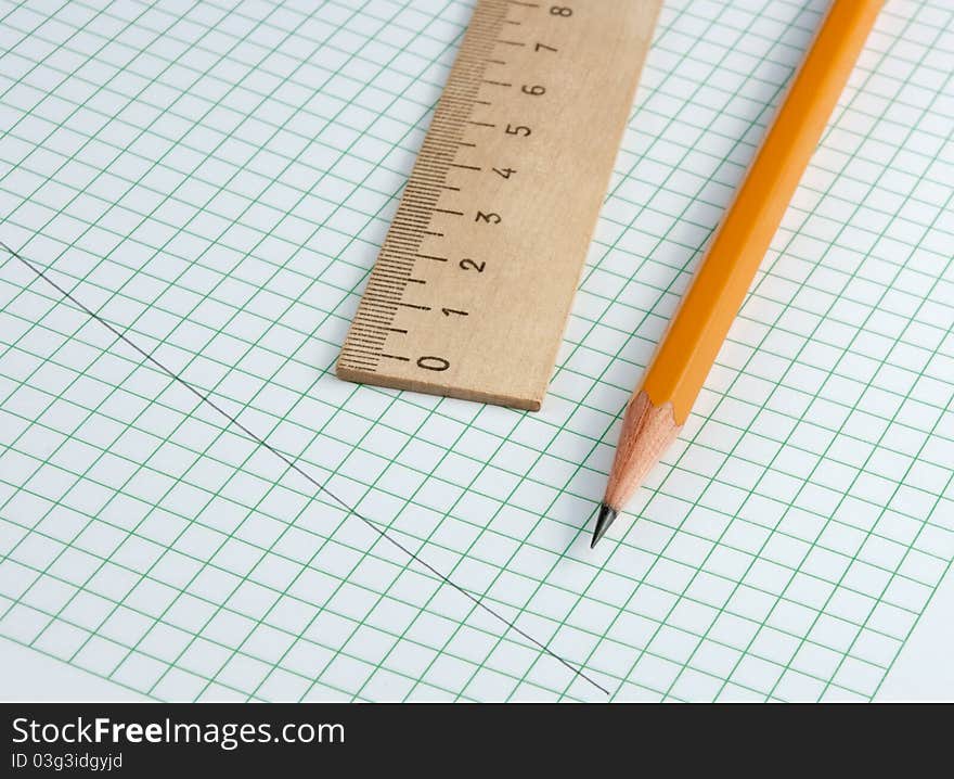 Pencil and ruler on a checkered paper