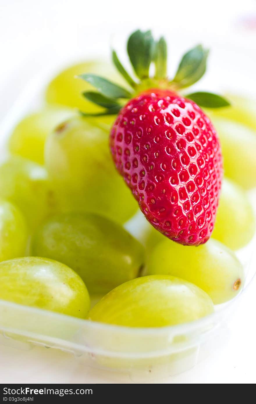 One beautiful straberry on the white grapes. One beautiful straberry on the white grapes