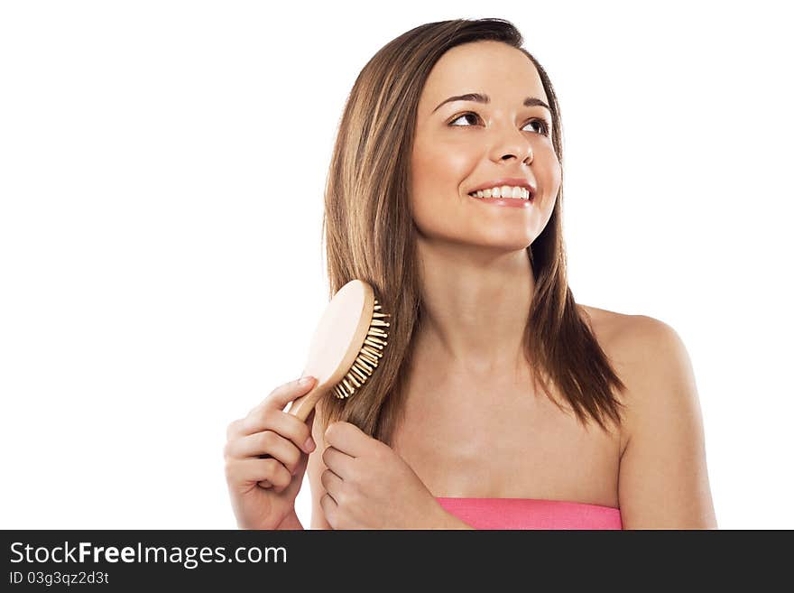 Lovely woman with hairbrush against white background