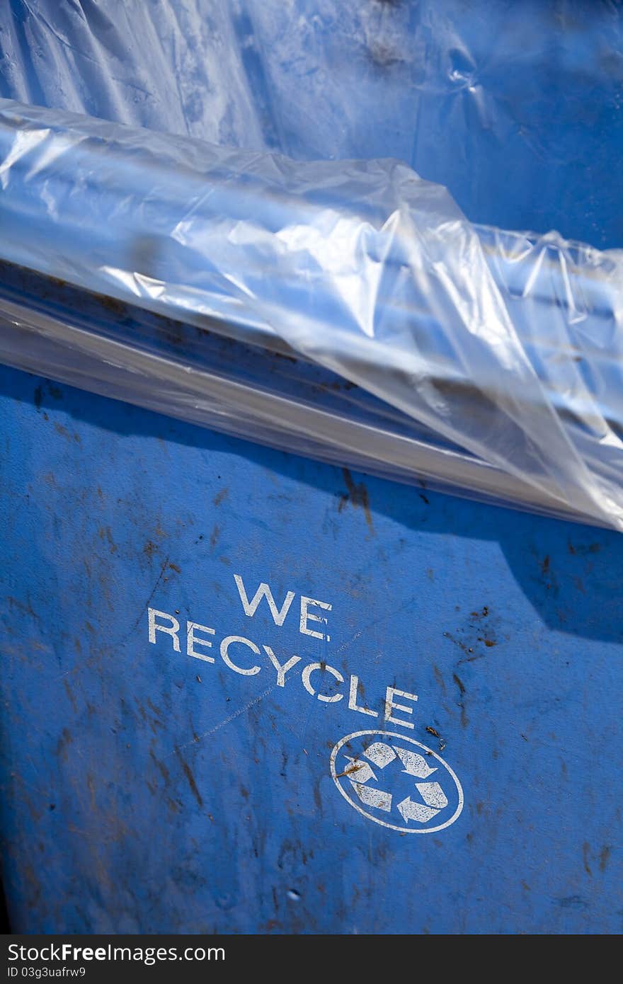 Blue recycling container with the words WE RECYCLE and the recycle logo printed on the side. Blue recycling container with the words WE RECYCLE and the recycle logo printed on the side.