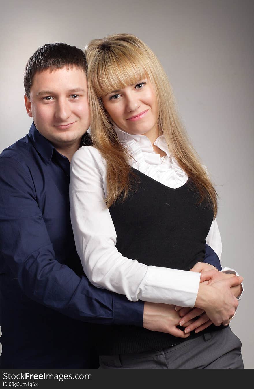 Cheerful family couple embrace blond woman