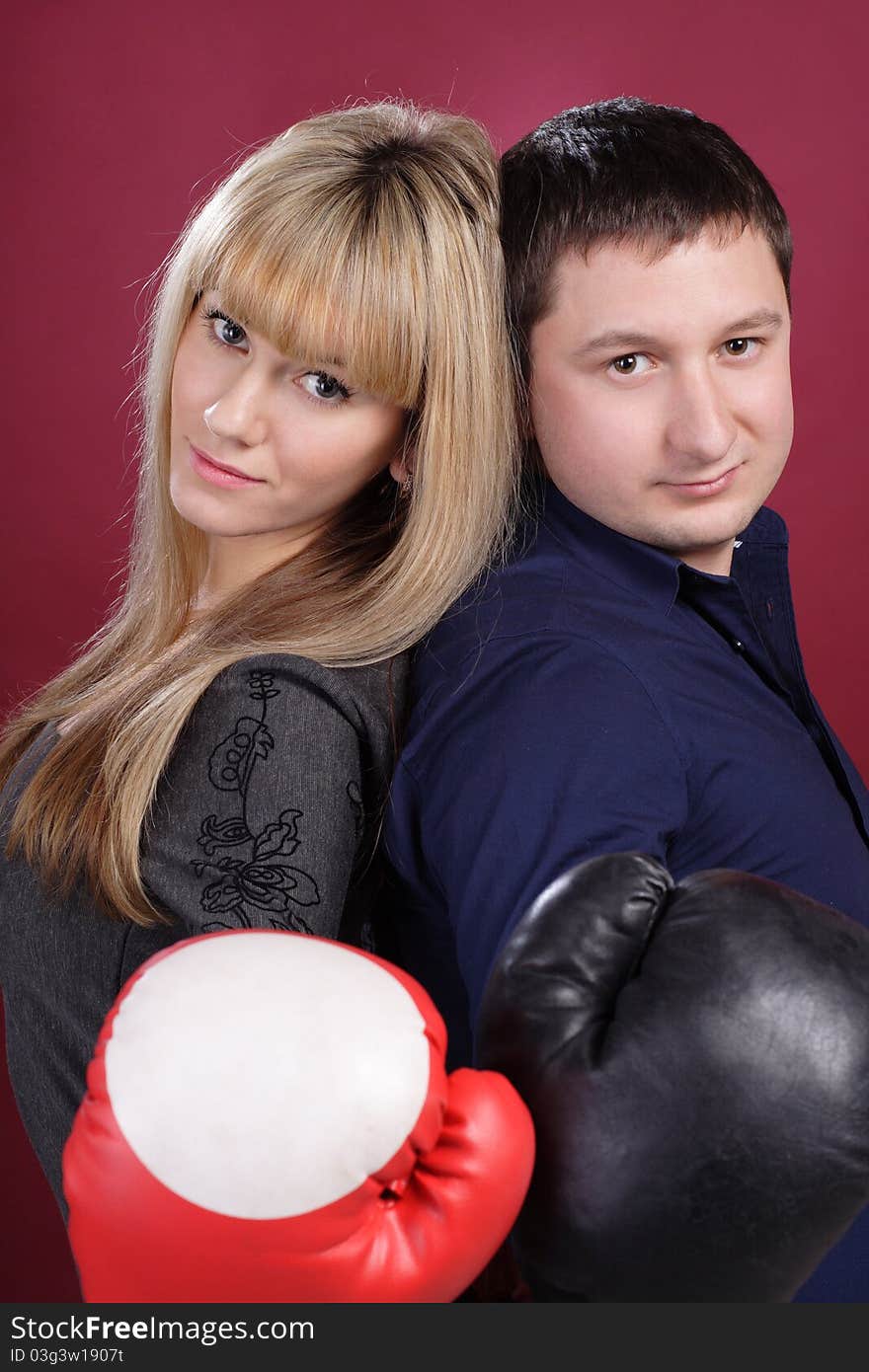 Attractive family couple in  boxing gloves on red