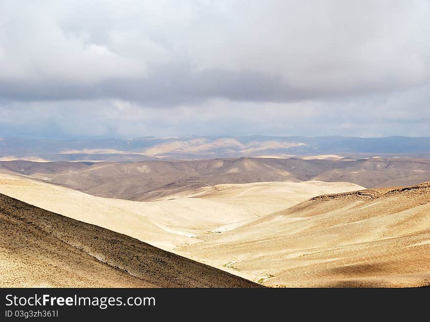 Fragment of ancient desert under dramatic sky. Desert Negev, Israel.