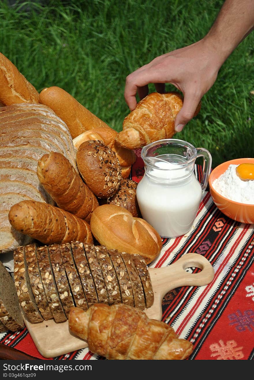 Image of tasty bakery products and hand reaching for a croissant. Image of tasty bakery products and hand reaching for a croissant