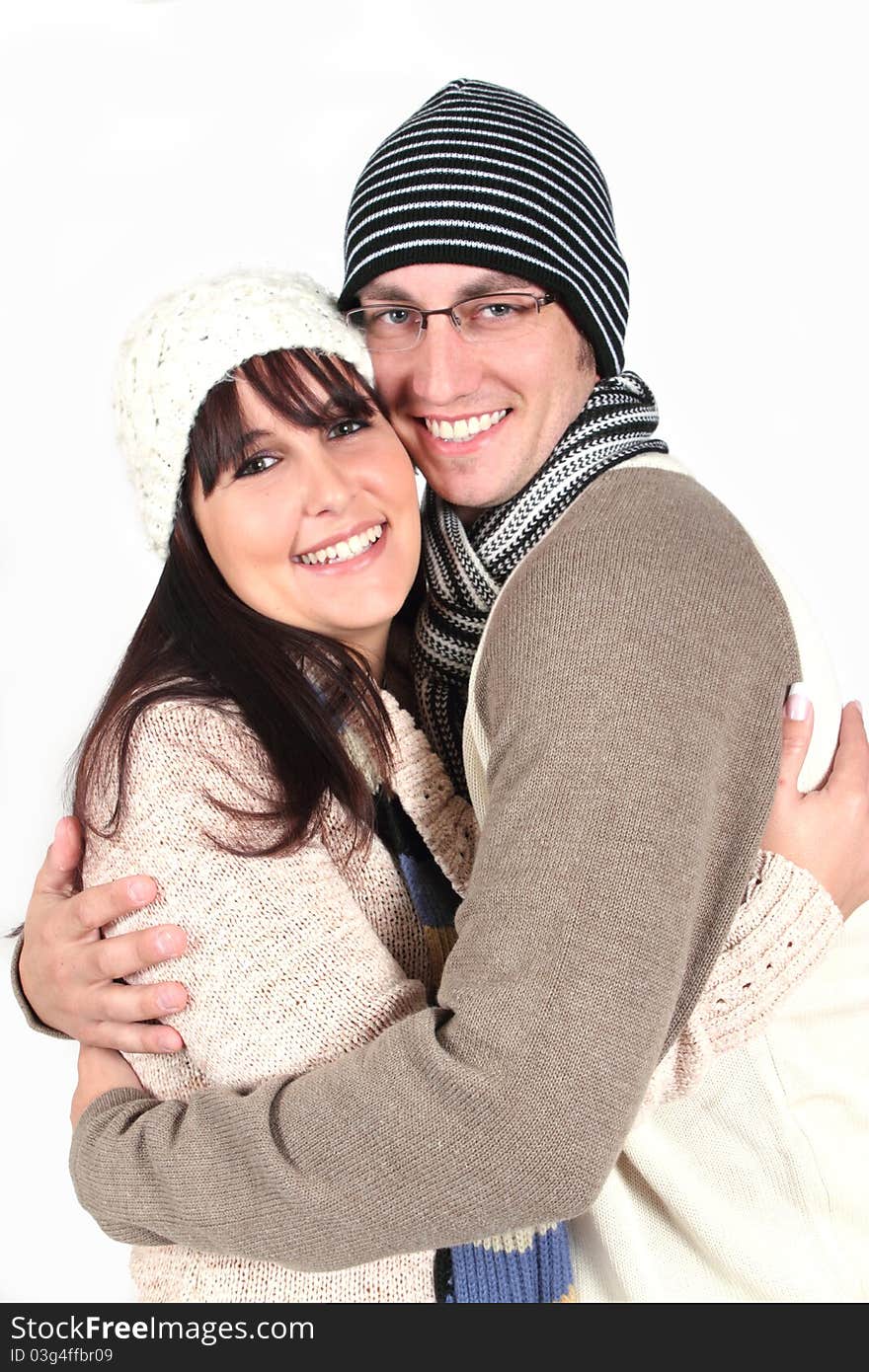 Young couple hugging in winter clothes on white background