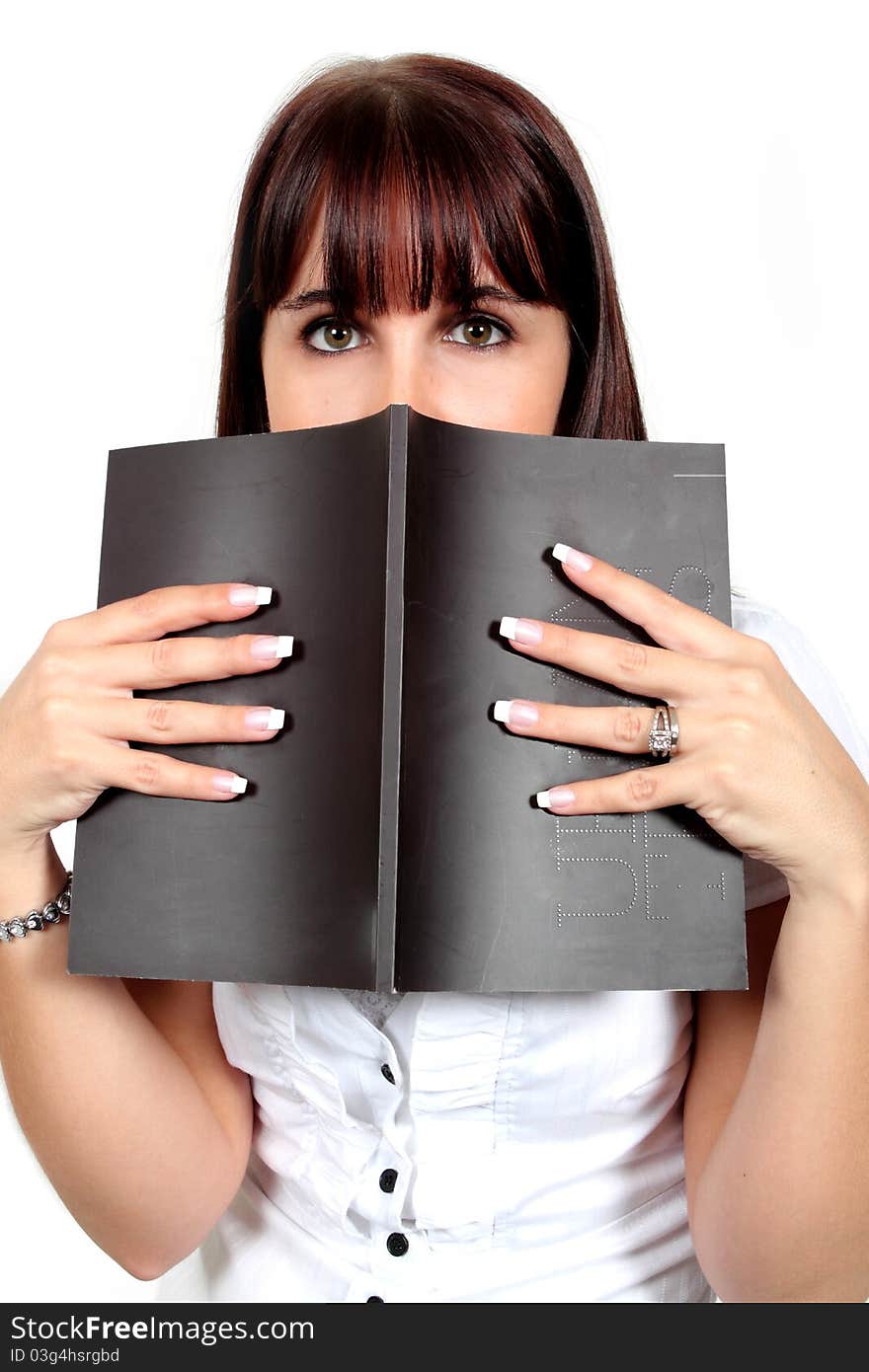 Young woman peeking over the top of a black book. Young woman peeking over the top of a black book