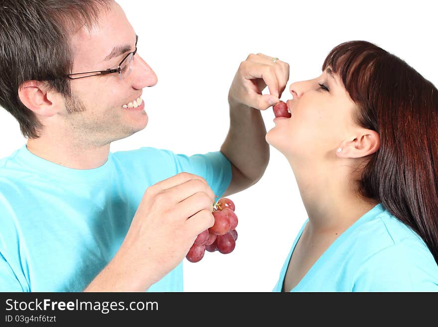 Man feeding woman grapes