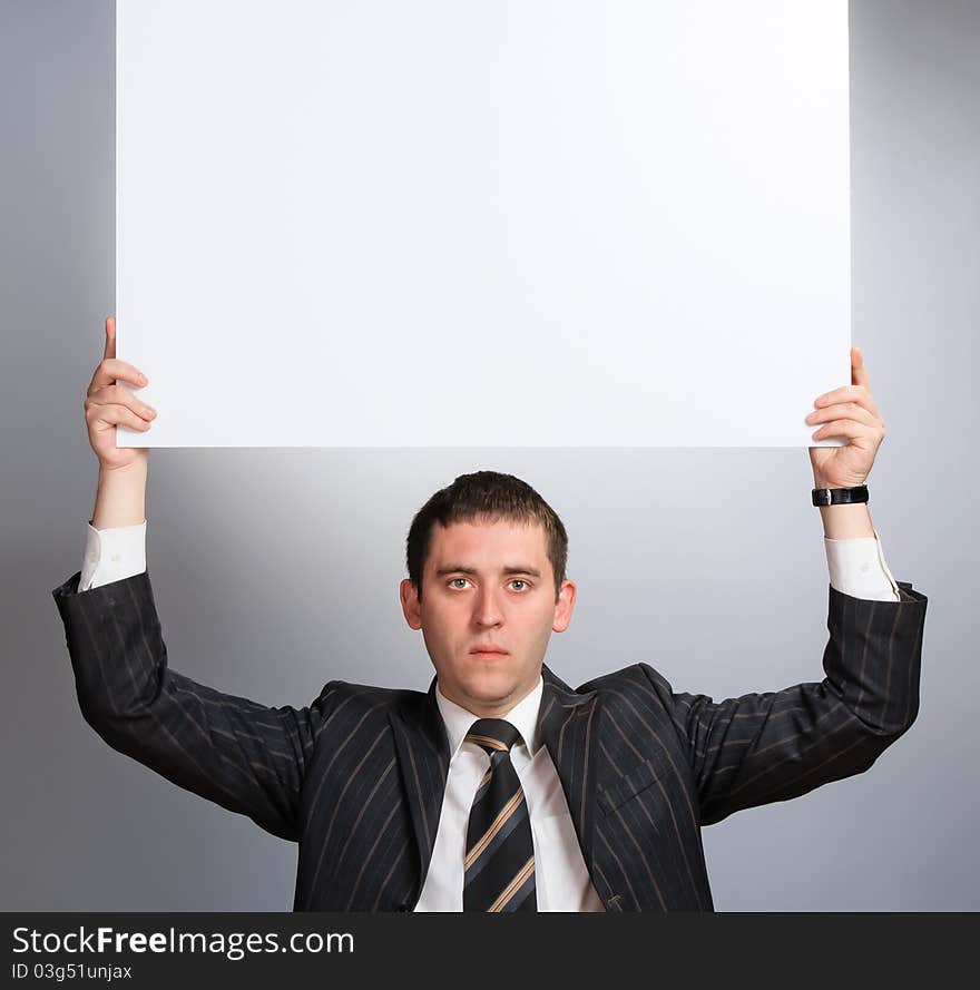 Business man holding a white card looking very serious. Business man holding a white card looking very serious