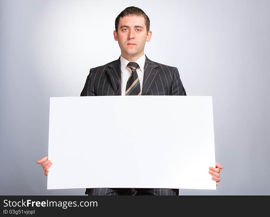 Business man holding a white card looking very serious. Business man holding a white card looking very serious