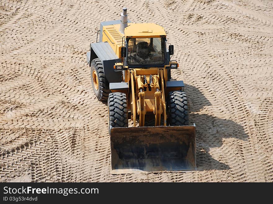 Big yellow excavator in sand pit