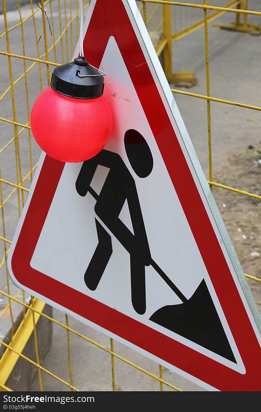 The road work sign with big red lamp. The road work sign with big red lamp