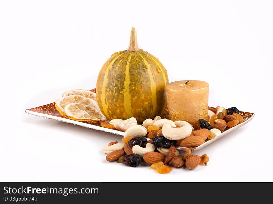 Pumpkin with candle lemon and nuts on the plate