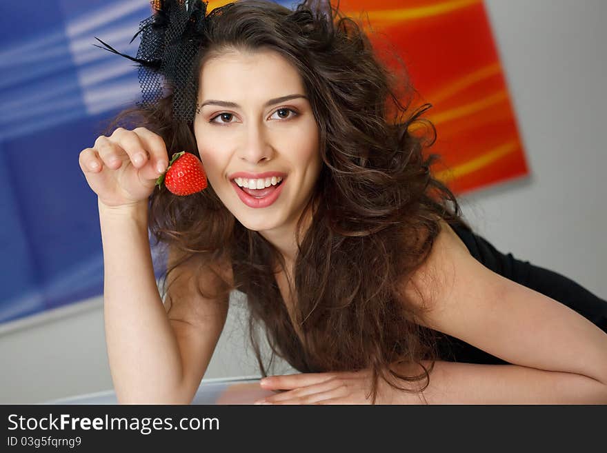 Young woman with red strawberry on roof of New car