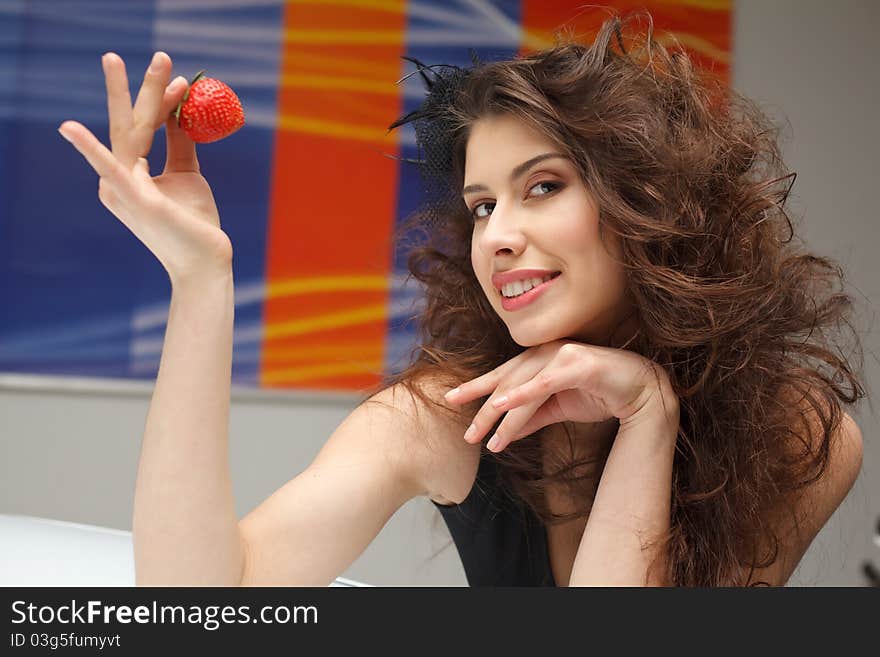 Young woman with red strawberry on roof of New car