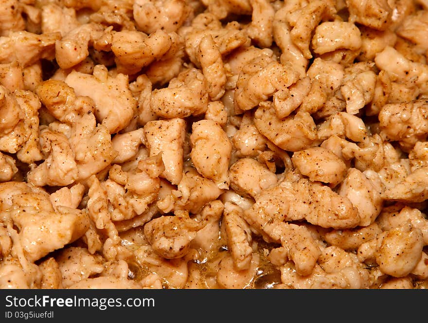 Slices of chicken fried in vegetable oil