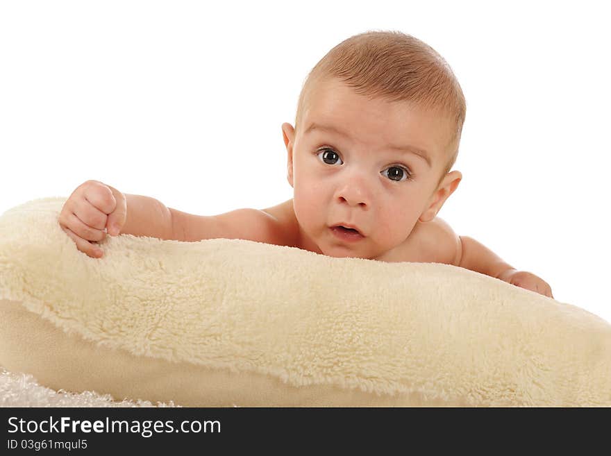 A close-up portrait of an adorable baby boy on a fluffy white pillow. Isolated on white. A close-up portrait of an adorable baby boy on a fluffy white pillow. Isolated on white.