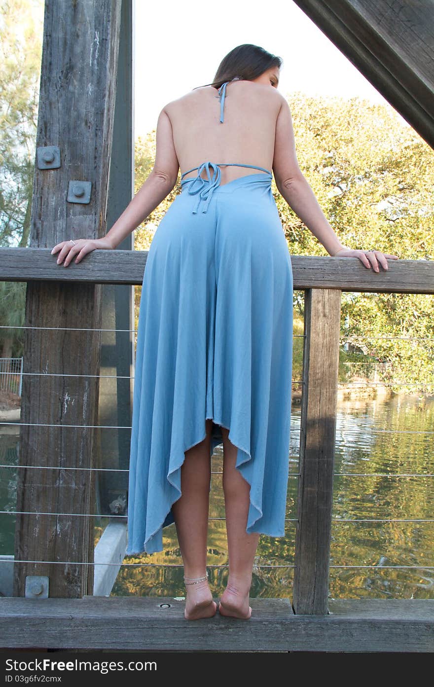 A young woman in a blue dress posing outdoors. A young woman in a blue dress posing outdoors.