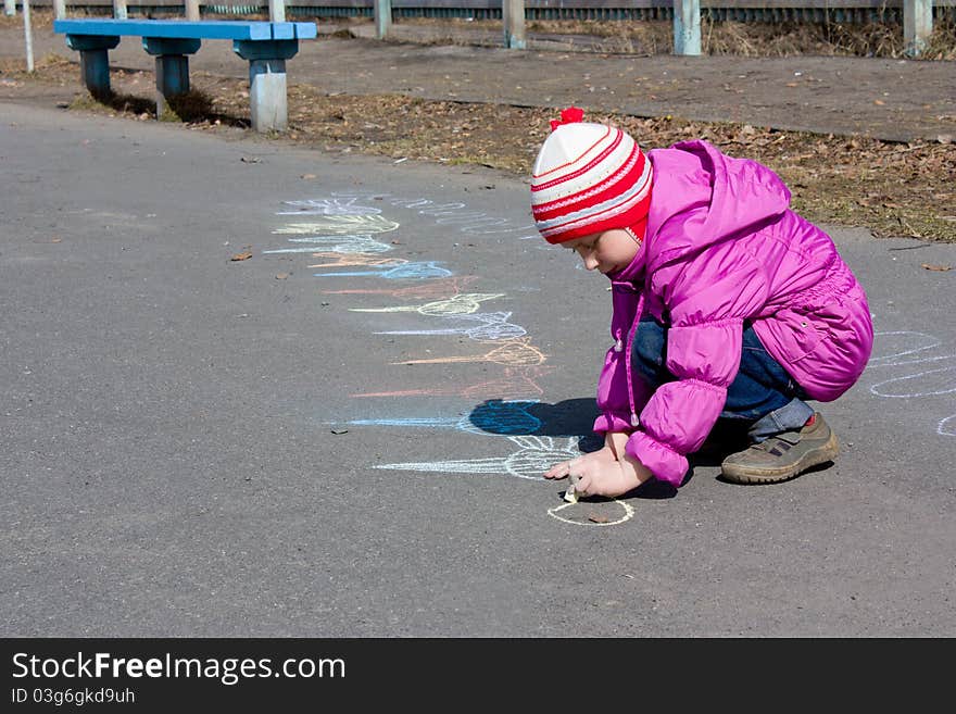 Girl drawing on the asphalt.