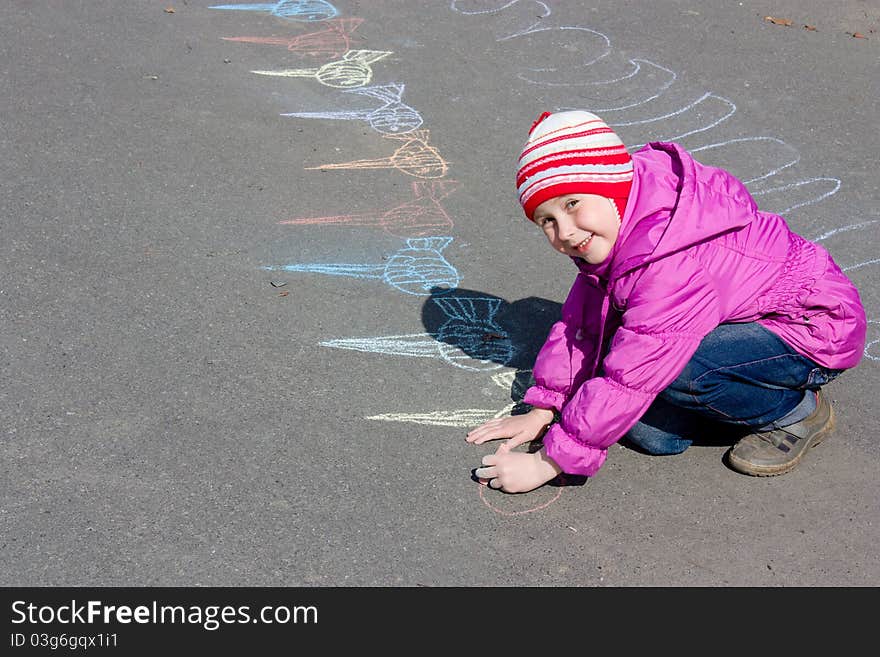 Girl drawing on the asphalt.