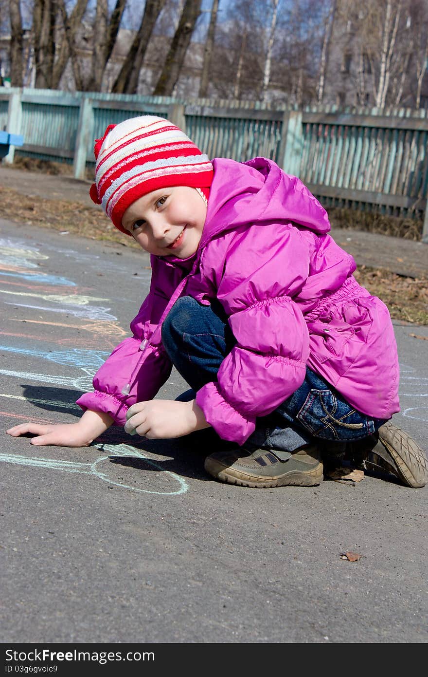 Girl drawing on the asphalt.