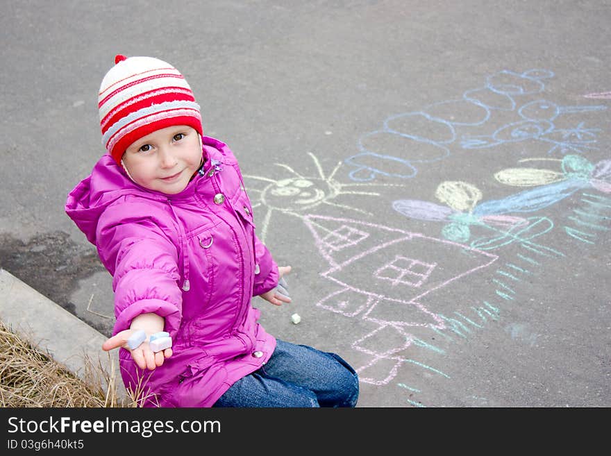 Girl drawing on the asphalt.