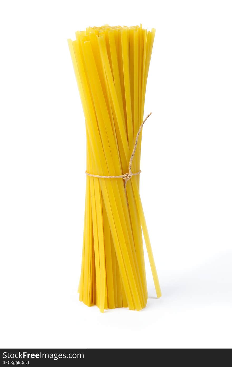 An image of raw yellow pasta on white background