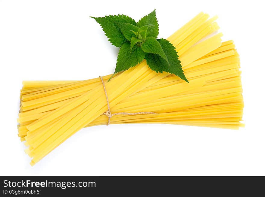 An image of raw yellow pasta and green plant. An image of raw yellow pasta and green plant