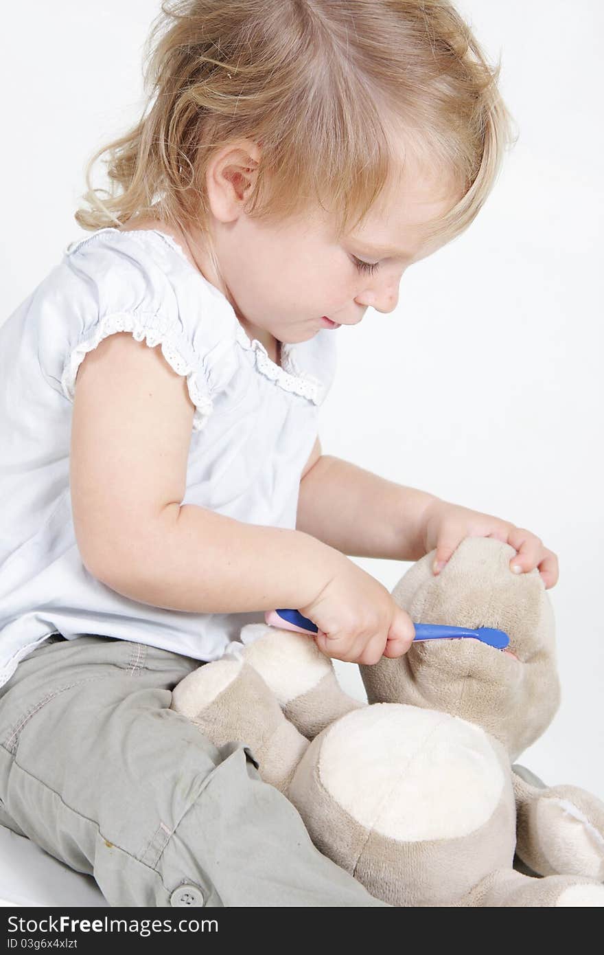 Cute child cleaning teeth to no-name toy hippo