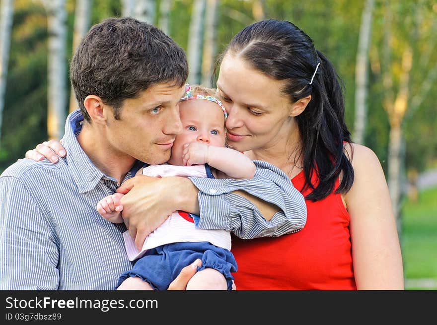 Happy mom and dad with their little daughter for a walk in the park. Happy mom and dad with their little daughter for a walk in the park