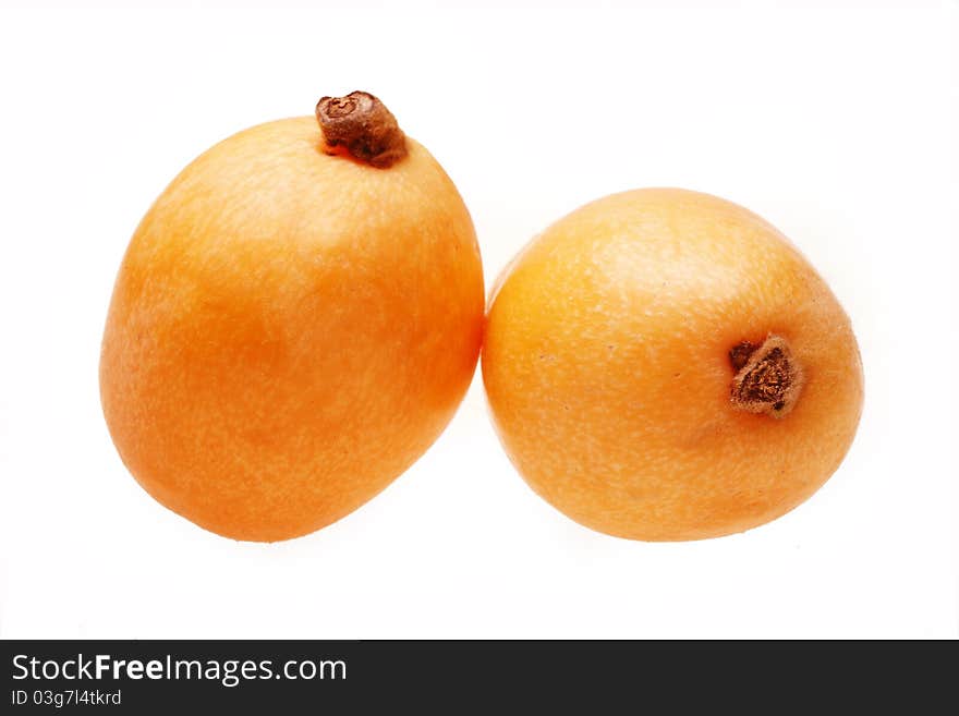 Two loquat fruits on white.