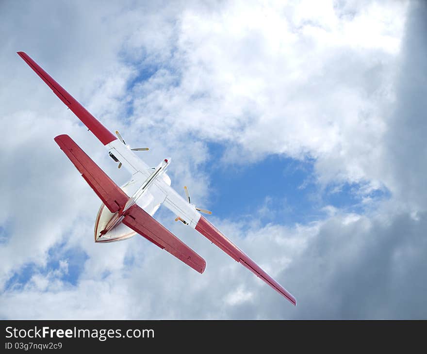 The plane flying up in the light-blue, pure sky between clouds. The plane flying up in the light-blue, pure sky between clouds