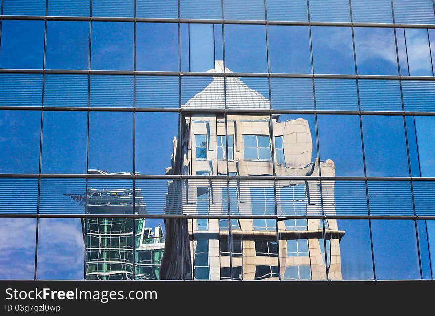 Buildings reflected in the mirrored windows of a modern building