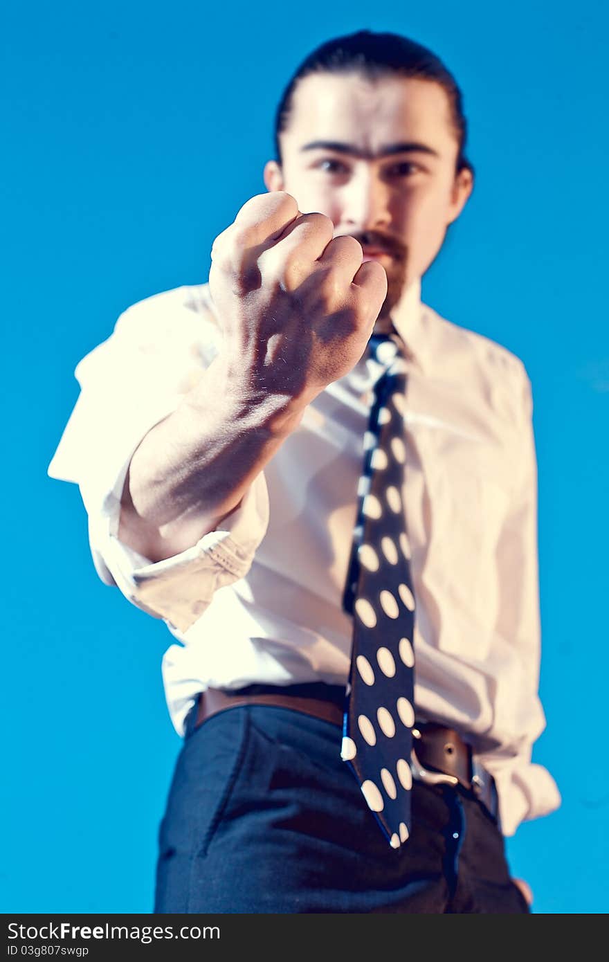 Businessman shows his fist on blue background