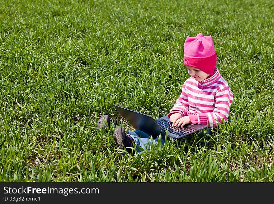 Little girl sitting with a noteboot