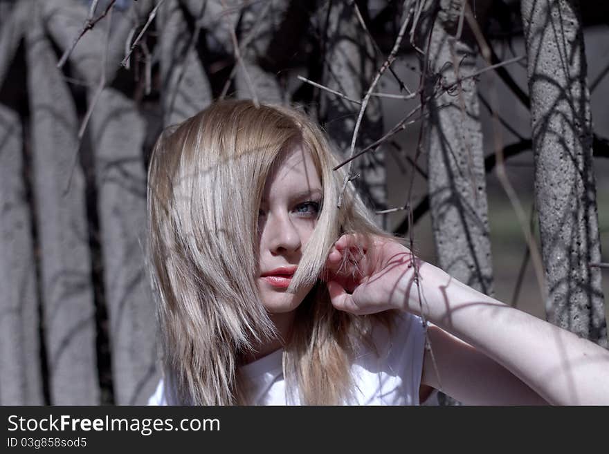 Beautiful caucasian blonde woman near old fence